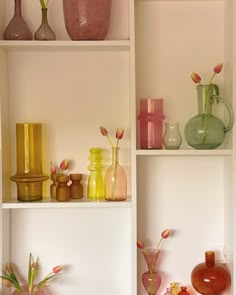 vases and other decorative items are displayed on the shelves in this white walled room