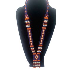 Colorful long seed bead Native American necklace with fun fringe in a striking pattern. This necklace says summer, beach, resort. Necklace measures 16 inches, pendant measures 4 1/2 inches from top to the bottom of the fringe. No clasp, just slip over your head. Striking with a swingy beach dress or a jean jacket. Shop more necklaces here: https://www.etsy.com/shop/BoutiqueByMaryam?section_id=21694658 Be sure to visit the rest of my shop here: https://www.etsy.com/shop/boutiquebymaryam Multicolor Southwestern Beaded Necklace With Dangling Beads, Orange Bohemian Hand-strung Beaded Necklace, Traditional Beaded Lariat Jewelry, Southwestern Beaded Necklace With Dangling Beads For Festivals, Southwestern Style Multicolor Necklaces With Dangling Beads, Southwestern Style Festival Beads With Dangling Details, Traditional Adjustable Beaded Fringe Necklaces, Traditional Adjustable Beaded Fringe Necklace, Artisan Beaded Fringe Necklaces For Festivals