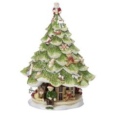 a ceramic christmas tree with people sitting on it's roof and around the base