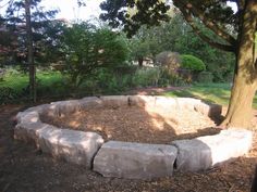 a stone fire pit in the middle of a park