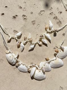 Discover the perfect blend of beachy elegance and boho charm with our Statement Seashell Choker Necklace. Handcrafted from natural white seashells, this unique piece is made for free spirits and beach lovers who want to carry a bit of the ocean with them wherever they go. 🌊 Whether you're dressing for a beach vacation, a seaside wedding, or simply adding a coastal touch to your everyday style, this natural seashell choker is designed to complement any look. Its minimalist, boho style makes it a Adjustable White Shell For Beach, White Adjustable Shell For Beach, White Adjustable Shell For Vacation, Adjustable White Shell For Beach Season, White Shell Necklace As Gift, Ocean-inspired Abalone Shell Decor, White Shell Jewelry For Beach Season, Handmade Sand-colored Jewelry For Beach, White Strand Shell Necklace Gift