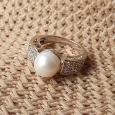 DESCRIPTION: Elegant sterling silver ring featuring a large freshwater white pearl and sparkling clear CZ stones. This timeless piece is perfect for engagements, weddings, or everyday wear. Ideal gift for her! BEST FEATURES: Adds a natural, timeless beauty. Durable and tarnish-resistant. Offers an affordable yet luxurious touch. Makes a bold, elegant statement. Ideal for special occasions or everyday elegance. OUR GUARANTEE "We stand by the quality of our jewelry! If you experience any issue wit Silver Rings With Diamond Accents And Pearl, Silver Pearl Drop Ring For Anniversary, Diamond White Cubic Zirconia Pearl Ring For Promise, White Pearl Drop Ring For Anniversary, Silver Pearl Drop Ring For Wedding, Silver Pearl Rings With Diamond Accents, White Pearl Rings With Diamond Accents, Silver Pearl Drop Ring, Silver Pearl Ring With Pearl Drop