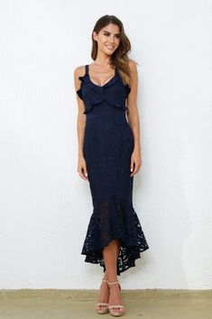 The Leanne Dress in Navy is a stunning lace midi dress perfect for attending a wedding or a black tie celebration. Product Details: V neckline with ruffle and lace detail Fishtail hem midi dress Exposed zipper at center back Adjustable straps Thick lining non-sheer 100% polyester Limited to no stretch in fabric Model Bonnie is 5'7" and wearing a size 2 Fit Note: The dress has limited to no stretch, so be sure to select your size based on your measurements. If you are between sizes, we recommend Evening V-neck Lace Dress With Ruffles, V-neck Ruffled Lace Dress For Party, Lace Mermaid Hem Evening Dress, Lace Evening Dress With Mermaid Hem, Lace Midi Dress With Ruffles For Night Out, Midi Length Lace Dress With Ruffles For Wedding, Ruffled Midi Dress For Prom, Formal Scalloped Lace Midi Dress, Evening Lace V-neck Dress With Ruffles