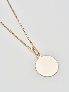 Sentimental? Same. The Disk Pendant handcrafted in L.A. from 14Kt gold is the perfect piece to engrave with a memorable message. Make it even more personal by stringing it from a chain of your choice. 14Kt Yellow Gold Disk Pendant Width: 20mm Sold solo with a silk cord Pictured with Petite Industrial Box Link Chain Shop all chain options Made in L.A. Engraved Yellow Gold Medallion Necklace In Sterling Silver, Minimalist Engraved Yellow Gold Coin Necklace, Engraved Yellow Gold Sterling Silver Medallion Necklace, Minimalist Engraved Medallion Jewelry, Everyday Engraved Yellow Gold Coin Necklace, 14k Gold Jewelry With Coin Pendant, 14k Gold Polished Round Pendant Necklace, 14k White Gold Coin Pendant Jewelry, 14k White Gold Jewelry With Coin Pendant