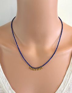 A dainty and versatile necklace of 2 mm faceted natural Lapis Lazuli round beads accented with gold-tone dangles. This necklace is 16.75" in length and has a 2" gold-filled extender chain so you can wear it short or long.  It looks great on its own or when worn in layers. It has gold-filled findings. NM Jewelry Design offers one-of-a-kind and limited edition jewelry. My creations are inspired by the cultures that traded along the ancient Silk Road. I am a Certified Gemologist and Accredited Jewelry Professional.   Please contact me for more information about the other necklaces shown in this listing. Gold Rondelle Beaded Necklaces, Gold Dainty Beaded Necklace With Faceted Beads, Dainty Gold Beaded Necklace With Faceted Beads, Gold Dainty Rondelle Beaded Necklaces, Dainty Gold Crystal Necklace With Faceted Beads, Gold Crystal Dangle Necklaces With Faceted Beads, Gold Dangle Necklace With Tiny Beads, Dainty Gold Faceted Beaded Necklaces, Gold Crystal Necklace With Dangling Beads For Gifts