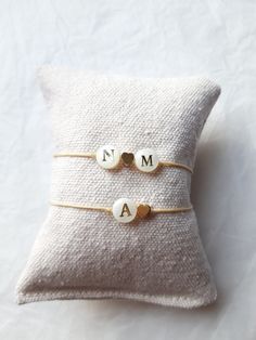 This bracelet mounted on braided nylon thread is made up of 8mm mother-of-pearl letter bead(s) (one or two initials of your choice), as well as a 5mm fine gold-plated brass heart and 925 silver beads gilded with fine gold of 4mm. The bracelet is adjustable (between approximately 15cm and 19cm) thanks to the sliding knot and fits the wrist! Please note: mother-of-pearl is natural, there is a possibility of having nuances. Each pearl is unique and may have imperfections. Properties of Mother-of-Pe Handmade Adjustable Yellow Gold Pearl Bracelet, Cream Beaded Bracelets As Gift, Adjustable Handmade Yellow Gold Pearl Bracelet, Adjustable Personalized Pearl Bracelet, Adjustable Initials Name Bracelet, Adjustable Heart Beads Pearl Bracelet, Adjustable Pearl Bracelet With Heart Beads, Gold Pearl Bracelet With Heart Charm As Gift, Adjustable Gold Name Bracelet With Heart Charm