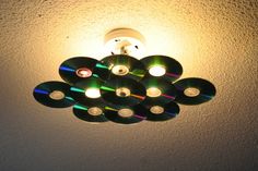 several cds are sitting on top of each other under a light fixture in a room