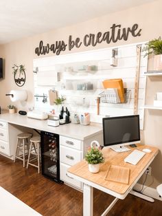 a desk with a computer on top of it in front of a wall that says always be creative