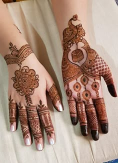 two hands with henna designs on them