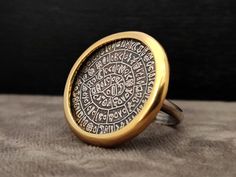 DESCRIPTION - Sterling Silver 925 - Ring - Gold Plated - Ancient Greek Minoan Phaistos Disc - Disc Diameter : 26 mm - 1.01 inches - Brand New - Stamped  925 - Made In Greece ETSY STORE Home Page : http://www.etsy.com/people/silveradosilverjewel?ref=si_pr Shop Page : http://www.etsy.com/shop/SilveradoJewellery?ref=pr_shop_more SHIPPING We ship worldwide using Registered Post Mail and we also provide you tracking number for easy tracking anytime. Shipping carrier : ELTA GREEK POST OFFICE PAYMENT We accept PAYPAL , Credit Cards Thank you very much or Efcharisto poli ( in Greek ) ! Collectible Round Symbolic Jewelry, Antique Engraved Ring For Commemoration, Unique Etched Round Jewelry, Ceremonial Etched Round Rings, Gold Etched Sterling Silver Rings, Gold Sterling Silver Rings With Etched Details, Unique Engraved Round Ring, Antique Round Jewelry For Commemoration, Antique Commemorative Round Jewelry