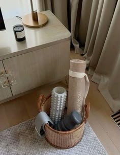 a wicker basket with various items in it on the floor next to a window