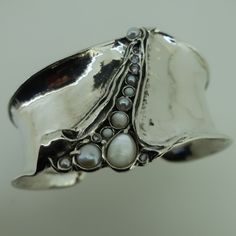 Unique Design by AMIR PORAN: Sterling silver wide cuff bracelet with MOP and PEARLS Wedding Gift Max Width: 1.57 inches. Length: 6.2 inches Can be made to fit any wrist MATCHING RING! https://www.etsy.com/il-en/listing/212541112/sterling-silver-long-stylish-garnet-ring?ref=shop_home_active_67&pro=1&frs=1 Please let me know if have any questions. our jewelry shop on Etsy: http://www.etsy.com/shop/Porans Thank you for visiting our shop. Please visit my shop policies for additional informat Modern Silver Pearl Bracelet For Formal Occasions, Modern Silver Pearl Bracelet With Oyster Design, Elegant Wide Band Metal Cuff Bracelet, Handmade Pearl Bangle Bracelet For Formal Occasions, Unique Silver Cuff Bracelet For Party, Silver Fusion Cuff Bracelet For Wedding, Silver Fusion Style Cuff Bracelet For Wedding, Elegant Wide Band Bracelets As Gifts, Elegant Wide Band Bracelets For Gifts