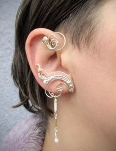 ORDERS PLACED AFTER DECEMBER 1, MAY ARRIVE AFTER CHRISTMAS OR NEW YEAR EVE due to the postal services being overwhelmed this time of year. Average delivery terms USA, France, Ireland - 3-4 weeks Australia, Canada - 4-6 weeks Netherlands, Spain - 2-3 weeks A pair of ear cuffs made of silver plated copper wire, white and golden glass beads with delicate danglings. The length of the dangles is 1 1/3" (3.4 cm).  These earrings are covered with metal protecting lacquer. No piercing needed, they are w Unique Adjustable Pierced Ear Climbers, Adjustable Unique Style Ear Climbers, Unique Nickel-free Metal Ear Cuff, Unique Handmade Metal Ear Cuff, Pierced Metal Ear Cuff With Unique Style, Unique Handmade Metal Ear Climbers, Unique Adjustable Pierced Ear Cuff, Unique Single Clip-on Earring In Metal, Unique Adjustable Metal Ear Climbers