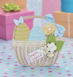 an easter basket with eggs and flowers in it on a table next to other boxes