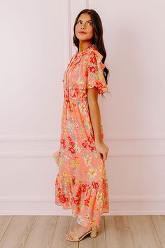 - Drape yourself in petals and twirl in the sun with this airy dress! - Chiffon material with a colorful abstract floral print - A built-in lining that ends above the ruffled hemline - A ruffled v-cut neckline with a tie detail - Short, loose ruffled sleeves - Pleated detail at the bodice - An elastic waistline - A flowy yet flattering silhouette that ends in a ruffled maxi length hemline Beach Floral Midi Dress With Ruffle Hem, Orange Ruffled Midi Dress For Vacation, Peach Ruffled Midi Dress For Garden Party, Orange Ruffled Midi Dress For The Beach, Tiered Floral Print Midi Dress For Beach, Peach Floral Print Midi Dress, Orange Summer Midi Dress With Ruffles, Pink Midi Floral Dress With Ruffles, Coral Dress For Spring Brunch