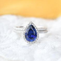 a blue and white diamond ring sitting on top of a blanket