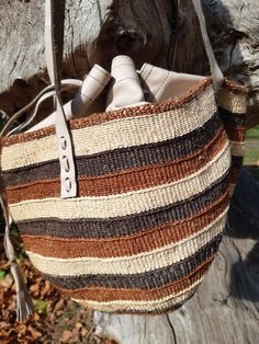 These individually woven colourful bags were woven by women in certain regions of Kenya https://en.wikipedia.org/wiki/Kiondo. The weaving skills were handed down from mothers and grandmothers. This bag has interwoven colours of shades of brown and beige. This bag is unique and is the only one of it's kind in the world. Handwoven Brown Leather Bucket Bag, Beige Handwoven Basket Bucket Bag, Brown Woven Leather Basket Bucket Bag, Brown Woven Leather Bucket Bag, Handwoven Leather Tote Crochet Bag, Handwoven Leather Crochet Tote Bag, Brown Leather Handwoven Bucket Bag, Handwoven Leather Bucket Bag In Natural Color, Natural Leather Woven Bucket Bag