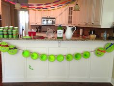 a kitchen decorated for teenage mutant birthday with green cups and decorations on the counter top