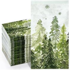 a stack of green and white paper with pine trees on it, in front of an image of snowflakes