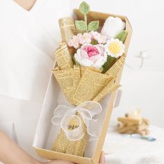 a person holding a box with flowers in it