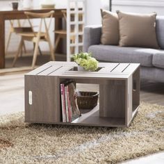 a living room with a couch, coffee table and bookshelf on the floor