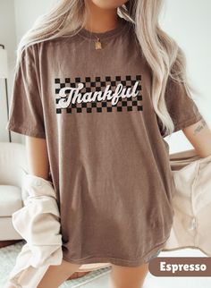 Embrace the festive season with our Thankful Shirt, a cute retro thanksgiving t-shirt, perfect addition to your Thanksgiving celebration. This Comfort Colors shirt, Happy Thanksgiving Shirt makes the perfect Thanksgiving gift, combining cozy season and fall vibes with a thankful spirit in a delightful turkey shirt. Welcome to Gift Vibe Shop - Your Fashion Wonderland! **SIZING** The shirts are unisex and run true to size, but size up for a more oversized fit. Please refer to the photo cards for a Cute Brown Crew Neck T-shirt, Retro Brown T-shirt For Fall, Thanksgiving Graphic Print Crew Neck T-shirt, Retro Crew Neck T-shirt For Fall, Brown Graphic Print T-shirt For Fall, Brown Letter Print T-shirt For Fall, Vintage Text Print T-shirt For Fall, Fall Crew Neck Shirt With Text Print, Brown Graphic Print Shirt For Fall