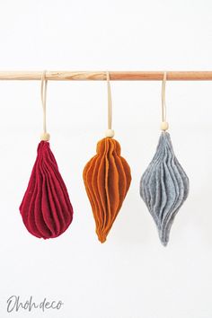 three different colored ornaments hanging from a clothes line