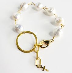 You want unique, you want different, you want elegant? This bracelet is all of those. It is a beautiful high grade Keshi pearl, hand-chained with 14kt gold wire, that is brought together in the center by a beautiful gold ring and at the end a beautiful three link chain lets it fit most all sizes. Clasp it on the circle or use the chain. At the end of the chain there is a beautiful 14kt gold cross reminding us of God's wisdom that is ready and available for us. Adjustable from approximately 6.5 i Elegant Wire Wrapped Pearl Bracelet, Wedding Pearl Bracelet With Metal Charm, Elegant White Wire Wrapped Pearl Bracelet, Adjustable Gold Pearl Chain Bracelet, Wedding Metal Bracelets With Pearl Charm, Wedding Pearl Charm Bracelets, 14k Gold-filled Pearl Charm Bracelet, Elegant Gold Wire-wrapped Bracelet, 14k Gold Filled Pearl Charm Bracelet