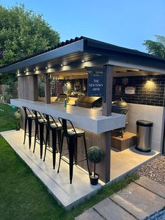 an outdoor bar with stools and tables