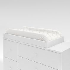 a white dresser with a baby crib in the middle