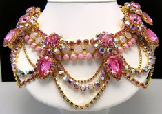 "Massive Showstopper Bib Necklace Earring Set Opalescent AB Pink Rhinestone Glass Marked Show Must Go On. Marked on All Three Pieces \"Show Must Go On\". The Necklace is Approximately 20\" Long and 3\" Wide. Earrings are Clip Backed and Measure 1 3/8\" Diameter. Condition is Excellent with No Flaws and Minimal Wear or Aging...appears never worn. I will be listing another pair of earrings that match this set separately if you prefer dangle earrings." Jeweled Crystal Dangle Jewelry, Crystal Jeweled Dangle Jewelry, Crystal Dangle Jewelry With Jewels, Pink Crystal Jewelry With Jewels, Pink Jeweled Rhinestone Necklace For Party, Pink Rhinestone Necklace For Party, Pink Crystal Costume Jewelry, Pink Crystal Jewelry For Evening, Pink Crystal-embellished Jewelry For Party