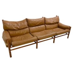 a brown leather couch sitting on top of a wooden frame