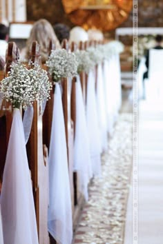 rows of pews decorated with baby's breath flowers and baby's breath ribbons