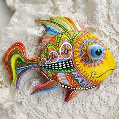 a colorful fish sitting on top of a white doily