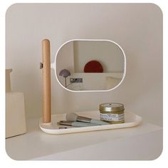 a white shelf with a mirror and some items on it