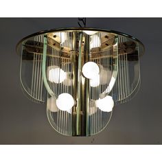 a chandelier with four lights hanging from it's sides and circular glass shades