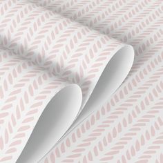 two spoons are sitting on top of a pink and white wallpaper