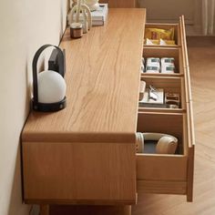 an open drawer on the side of a wooden counter next to a window with curtains