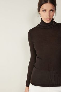 Long-sleeve high-neck tubular top made from a wool-silk blend. Winter Fine Knit Mock Neck Top, Winter Fine Knit High Neck Mock Neck Top, Elegant Mock Neck Turtleneck Top For Winter, Fitted Fine Knit High Neck Turtleneck, Fitted Fine Knit Turtleneck, Chic High Neck Fine Knit Turtleneck, Chic Fine Knit High Neck Turtleneck, Elegant Turtleneck Mock Neck Top, Fall Wool Top With Funnel Neck