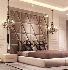 a large bed sitting in the middle of a room with chandeliers hanging from it's ceiling