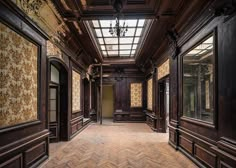 an empty room with wood paneling and decorative wallpaper on the walls is shown