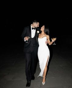 a man in a tuxedo and a woman in a white dress walking together