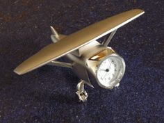 a clock is sitting on the floor next to a surfboard shaped like a plane