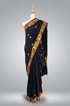 Formal Kashmiri Saree In Black, Pure Crepe Saree Regal Chinar, Hand Aari Embroidered Saree Immerse yourself in the rich heritage of Kashmiri craftsmanship with this exquisite Chinar Pure Crepe Saree adorned with intricate hand aari embroidery. The luxurious black crepe fabric serves as a canvas for the exceptional artistry of the skilled artisans of Kashmir, who dedicate countless hours to create the breathtakingly beautiful motifs adorning this saree. The centerpiece of this saree is the heavy Black Embroidered Pre-draped Saree For Navratri, Festive Black Embroidered Pre-draped Saree, Black Silk Saree With Resham Embroidery, Black Silk Pre-draped Saree With Resham Embroidery, Designer Black Katan Silk Blouse Piece, Designer Black Raw Silk Saree, Black Katan Silk Blouse For Designer Wear, Black Bollywood Embroidered Fabric With Border, Bollywood Style Black Embroidered Fabric