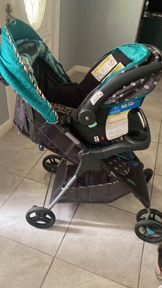 a baby sitting in a stroller on the floor