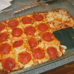 a large pepperoni pizza sitting on top of a pan