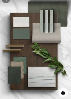 an assortment of different colors and materials on top of a wooden table with green leaves