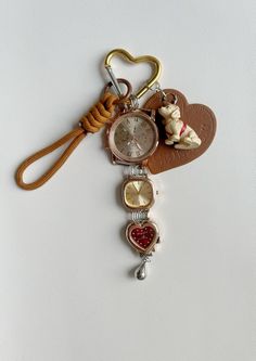 a heart shaped keychain with charms attached to it's side on a white surface