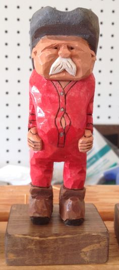 a wooden statue of a man with a mustache