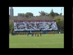 a group of people standing on top of a soccer field next to a large banner